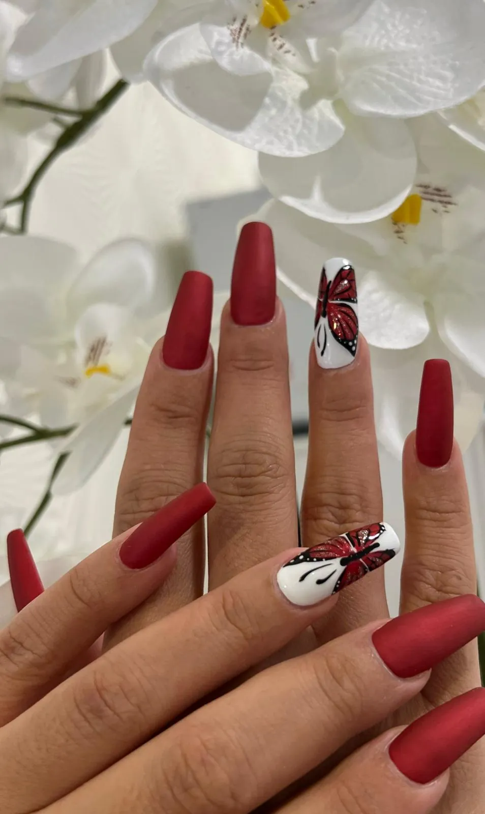 Matte rote Nägel mit Floral-Design